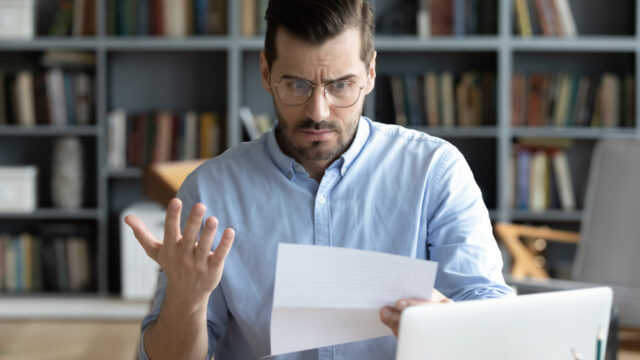 Man,Sit,At,Desk,In,Home,Office,Receive,Correspondence,Holding